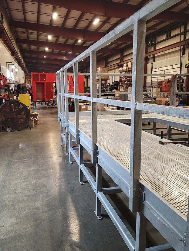 A large warehouse with a metal walkway in the middle of it.