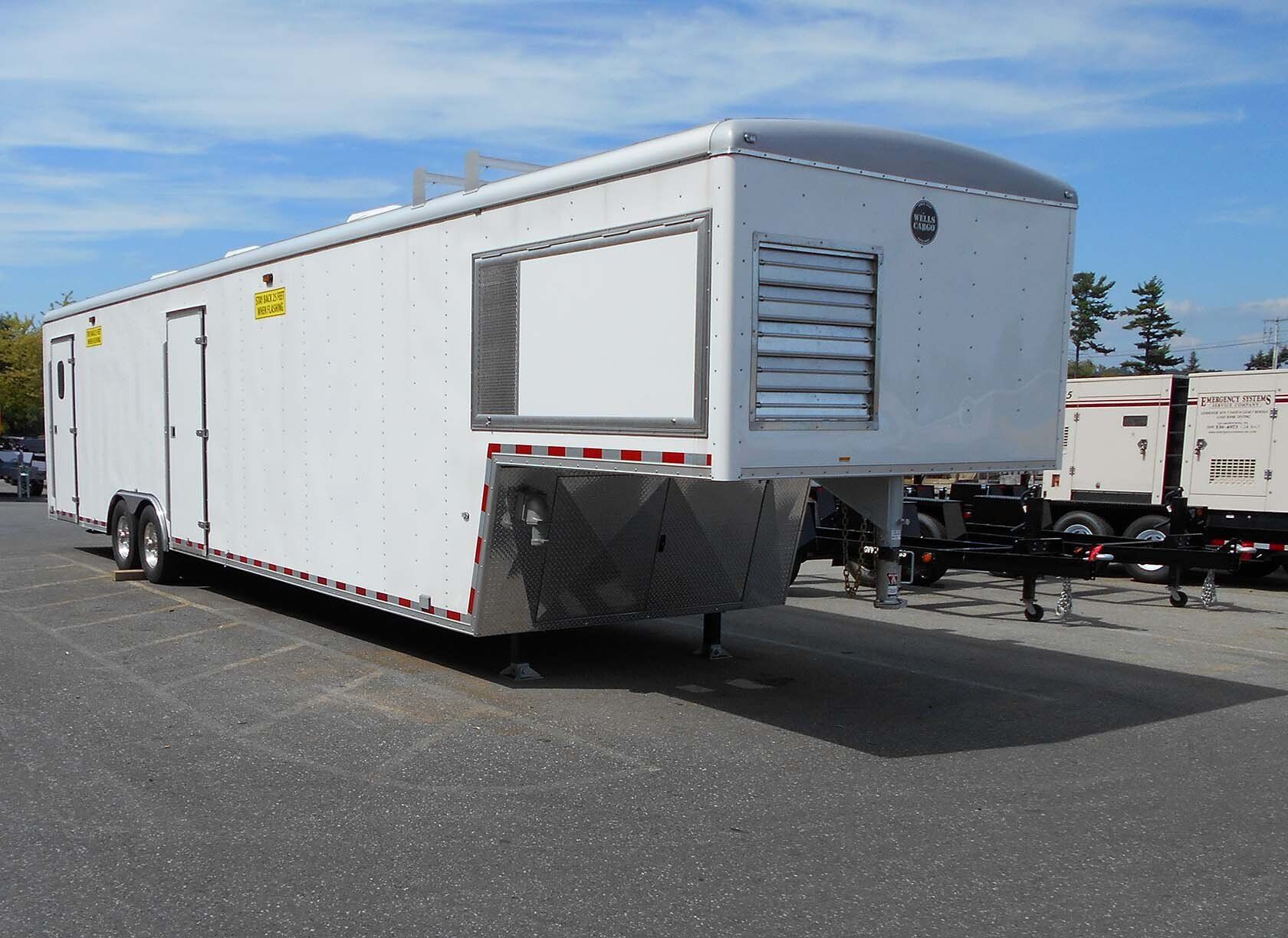 A white trailer is parked in a parking lot.