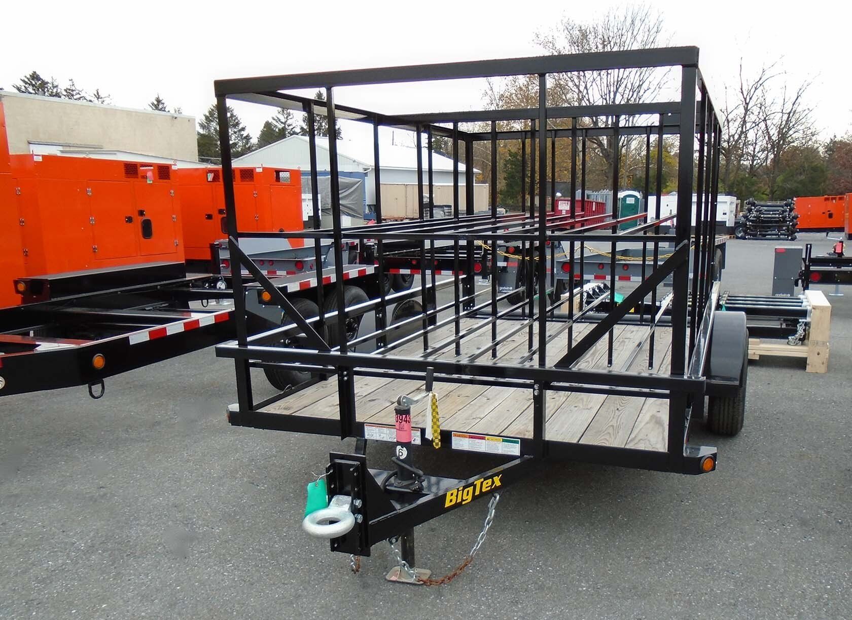 A trailer with a cage attached to it is parked in a parking lot.