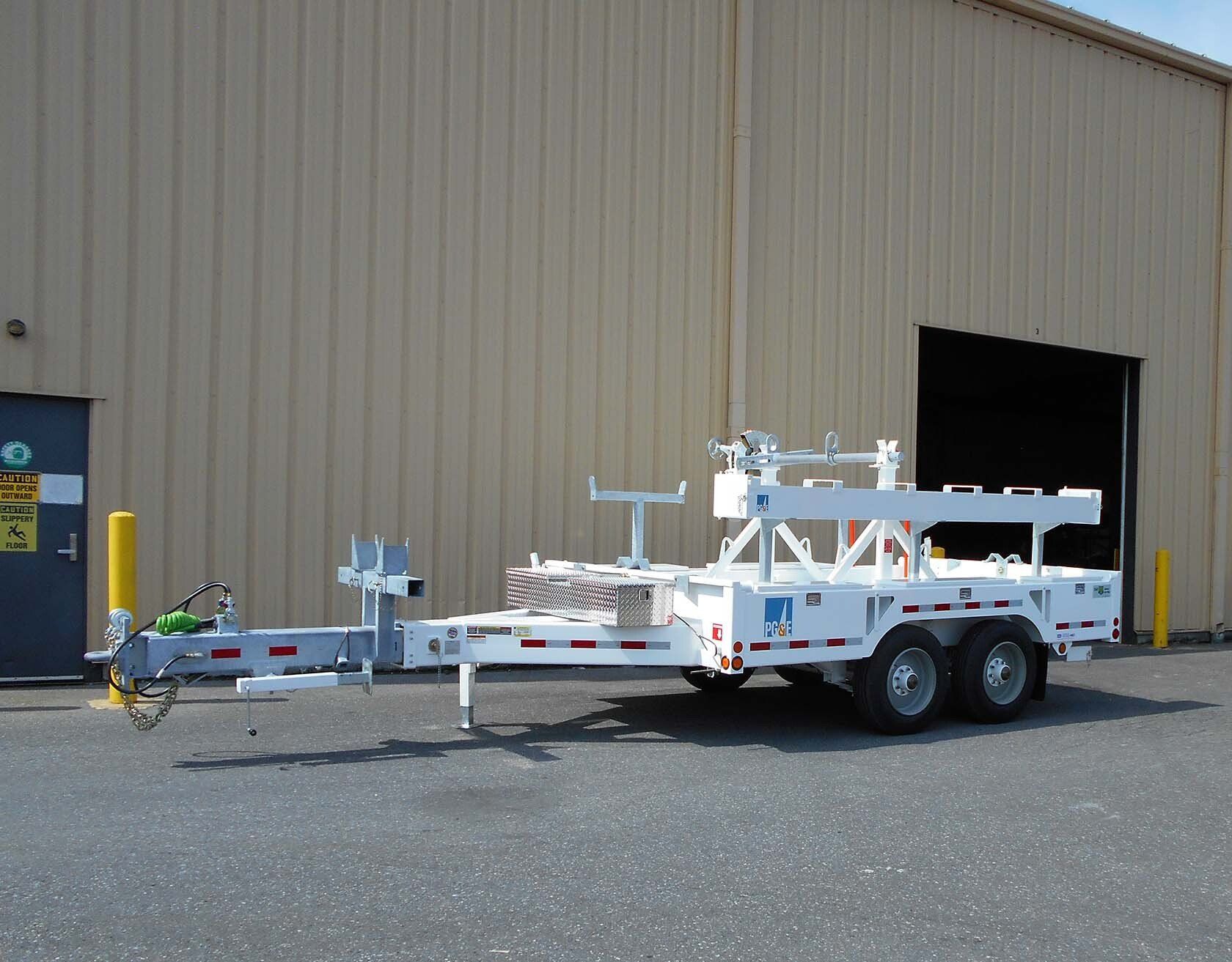A white trailer is parked in front of a building