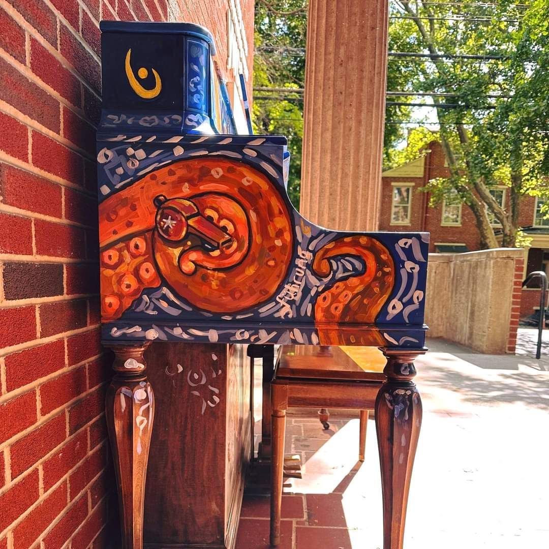 A piano with a painting of a cat on it