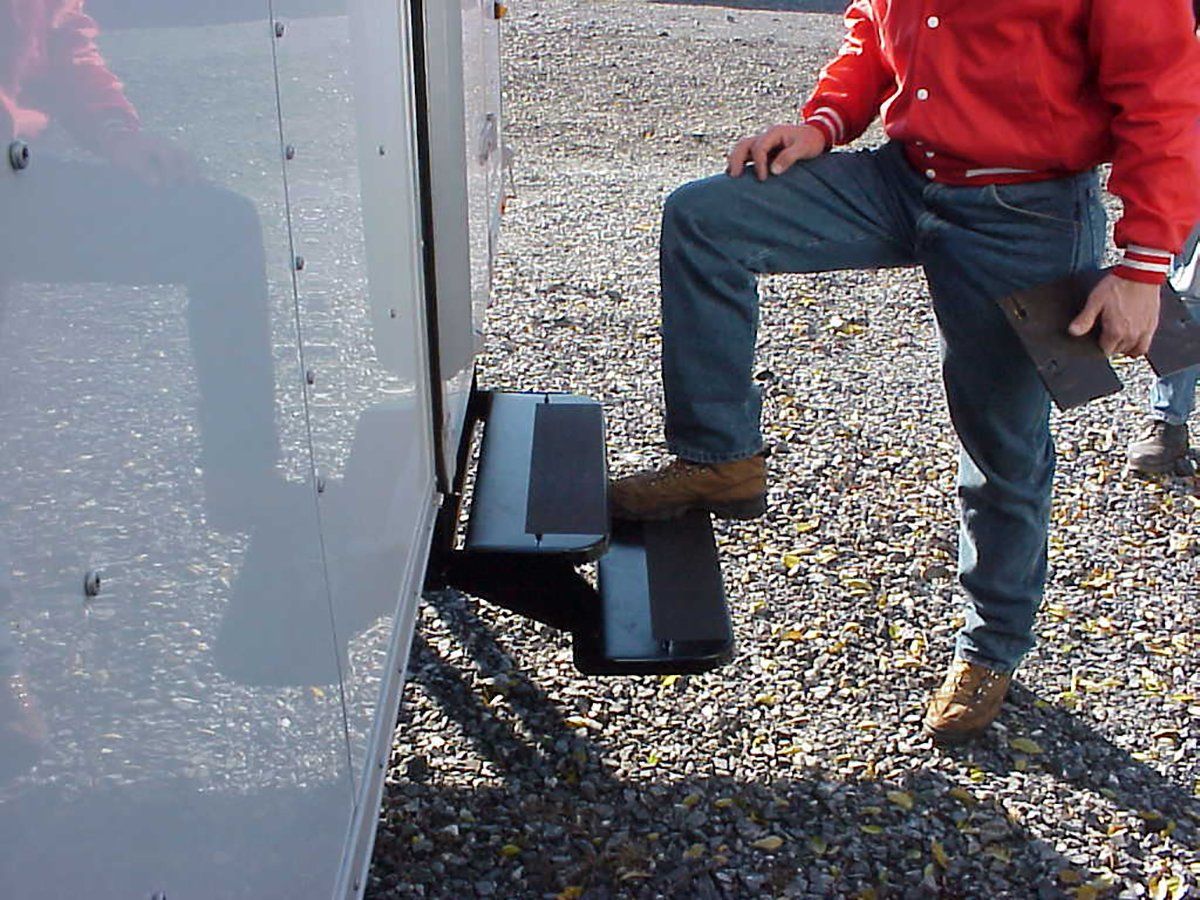 A man in a red jacket is standing on a step