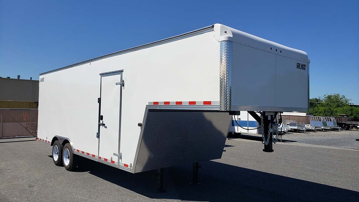 A white trailer is parked in a parking lot.
