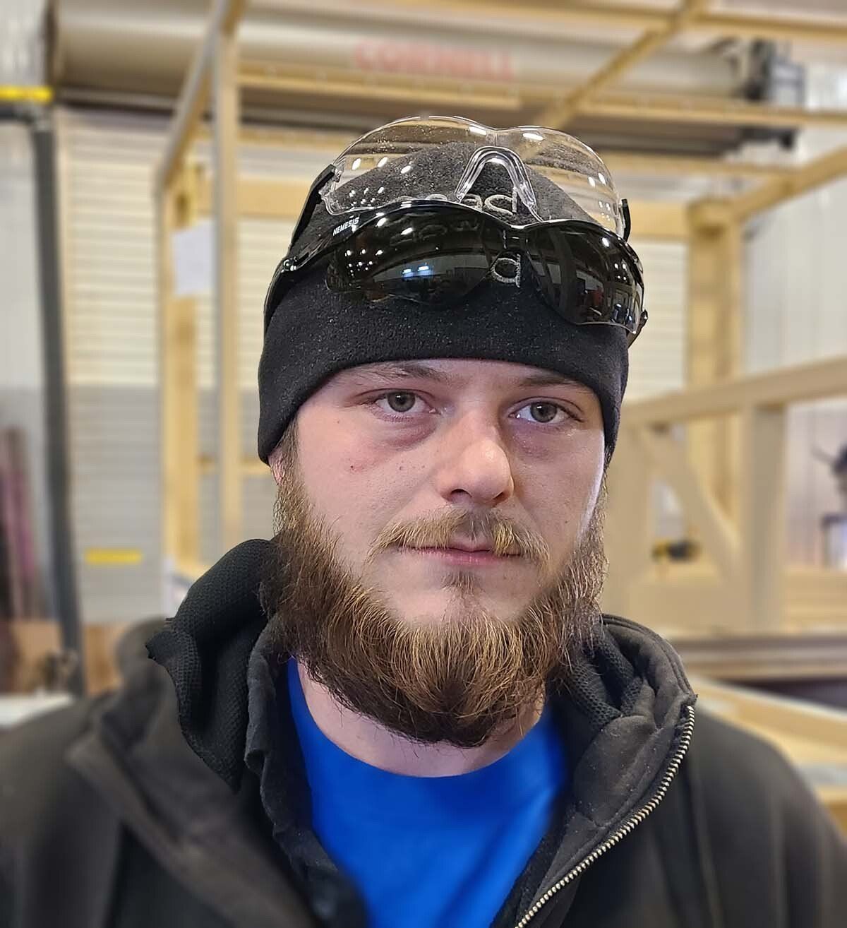 A man with a beard wearing a beanie and sunglasses.