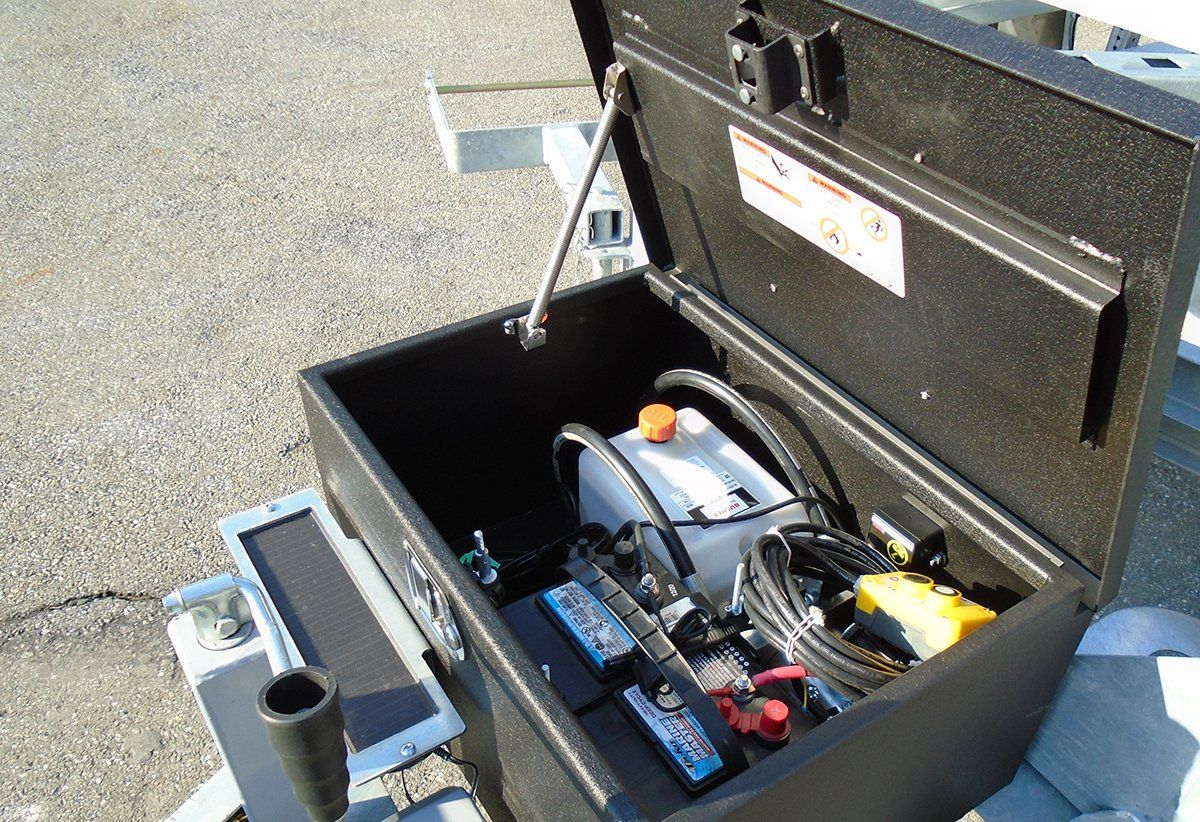 A black box with the lid open has a battery in it