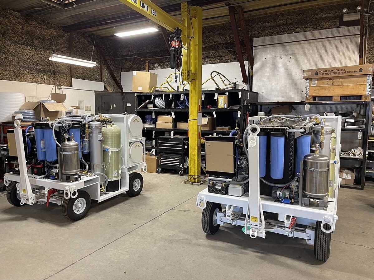 Two trucks are parked in a warehouse next to each other.
