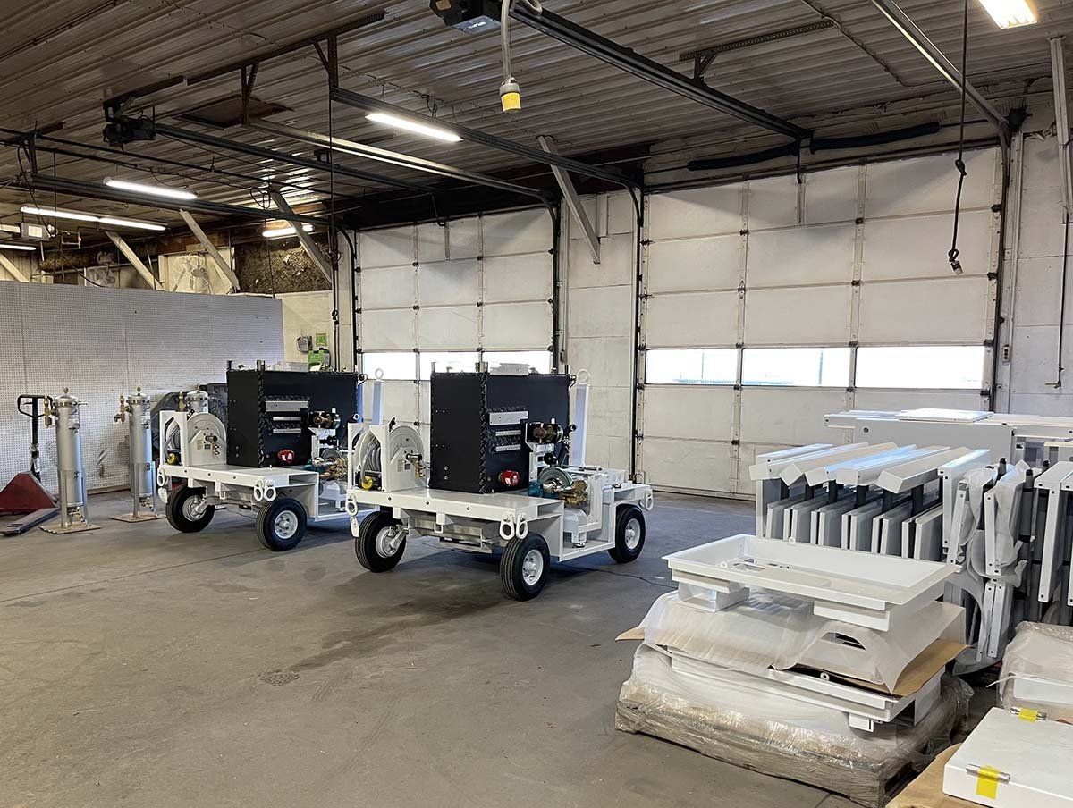 A warehouse with a row of trucks parked in front of a garage door.