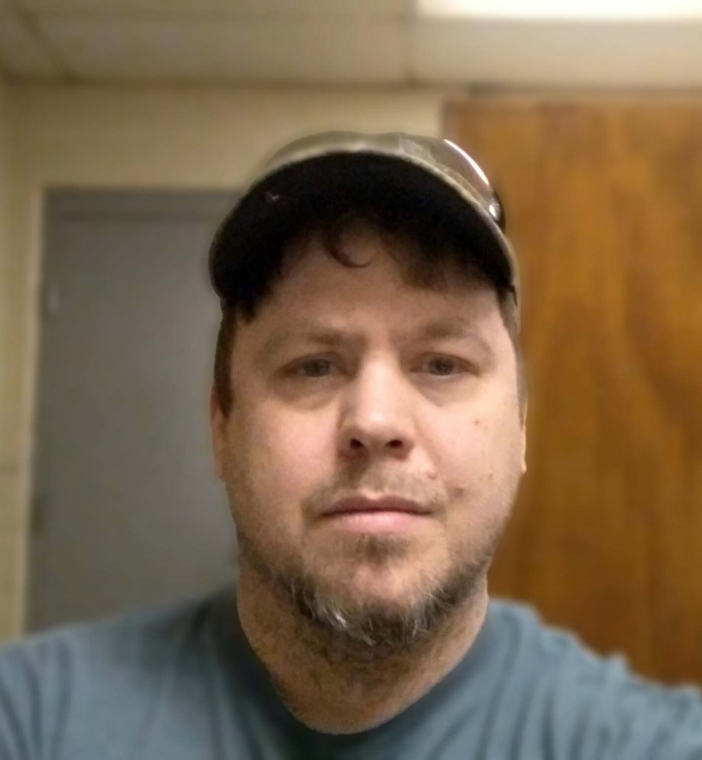 A man wearing a hat and sunglasses is taking a selfie