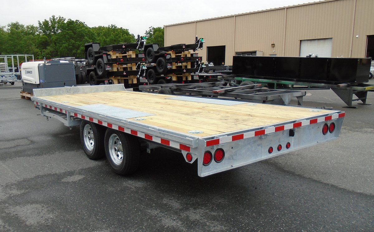 A flatbed trailer is parked in front of a building