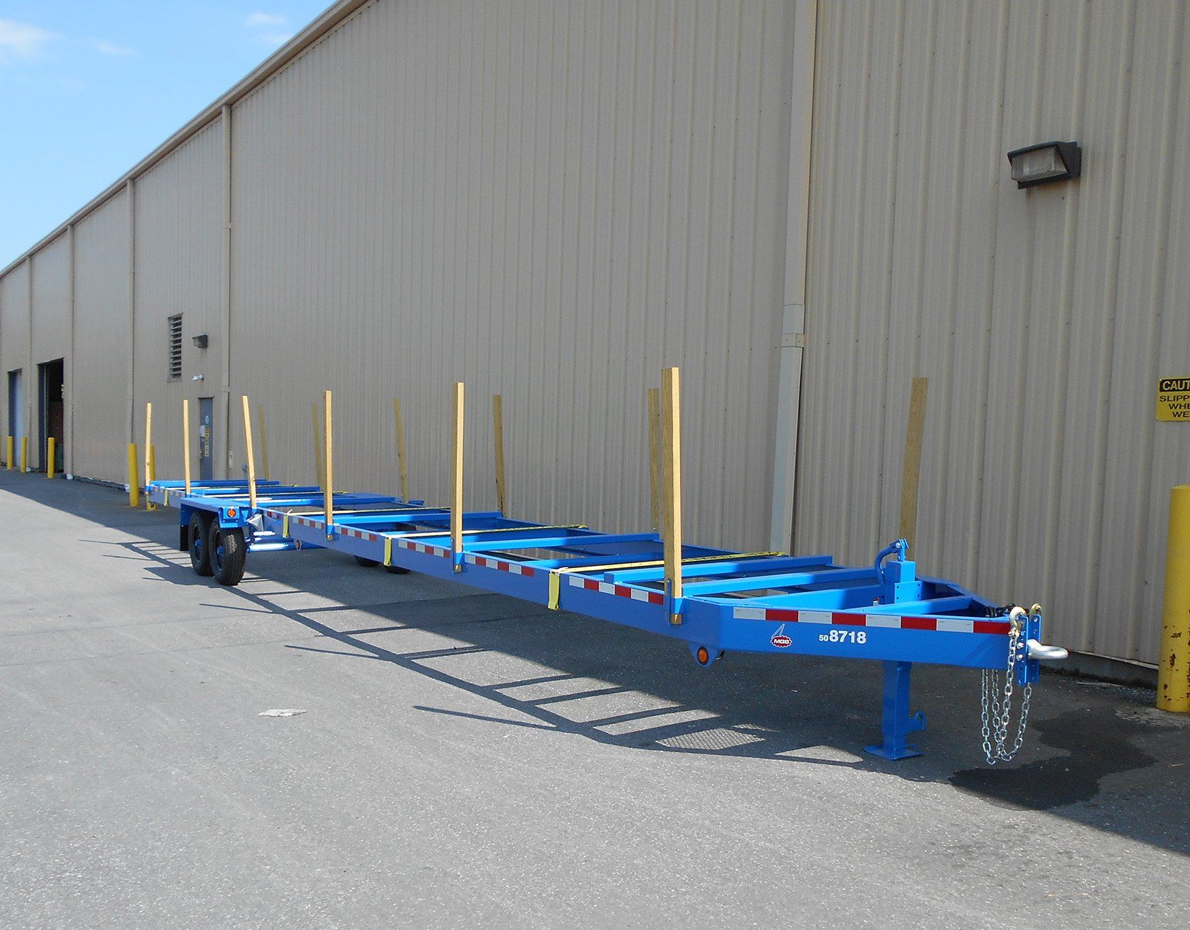 A blue trailer is parked in front of a building