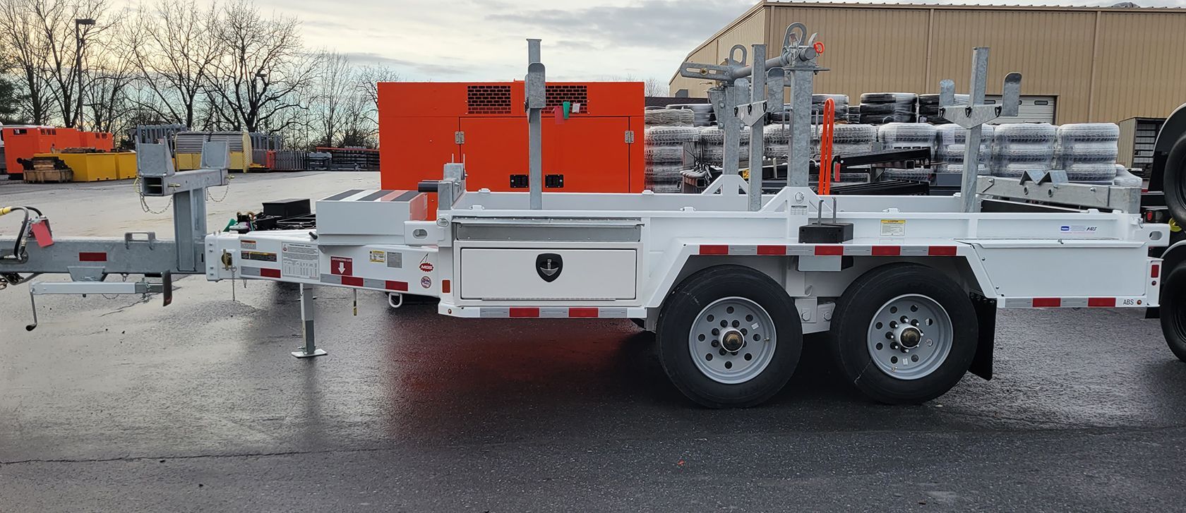 A trailer with a generator attached to it is parked on the side of the road.
