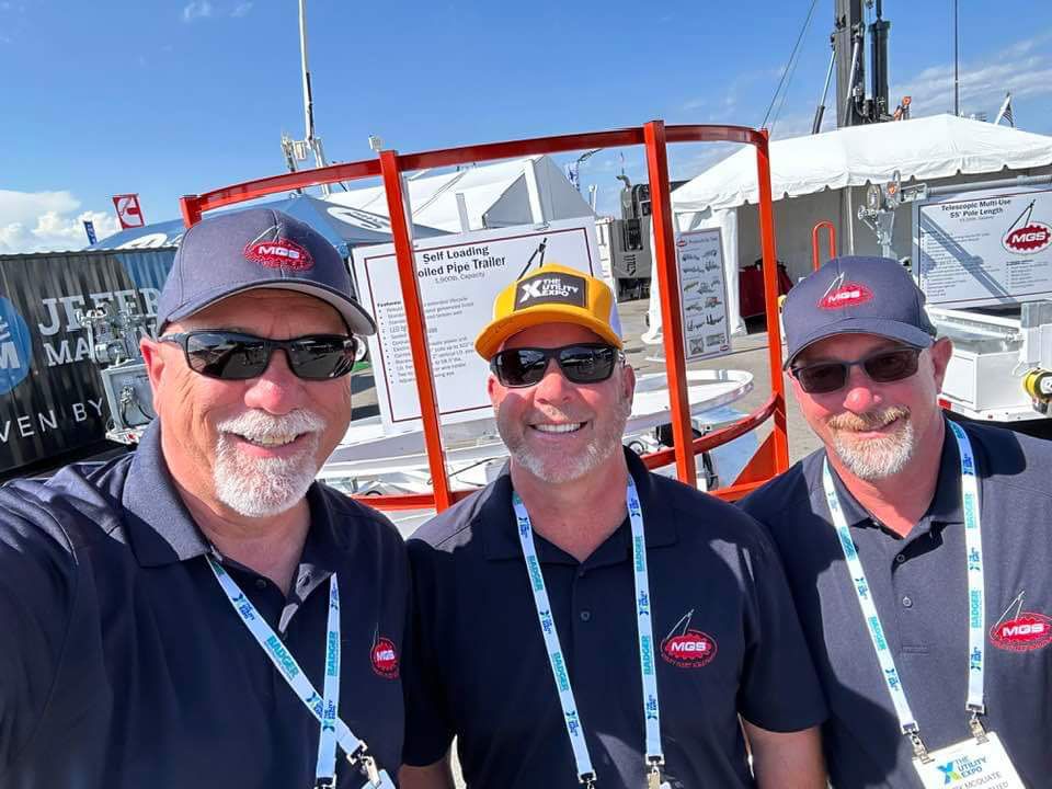Three men are posing for a picture at a boat show.