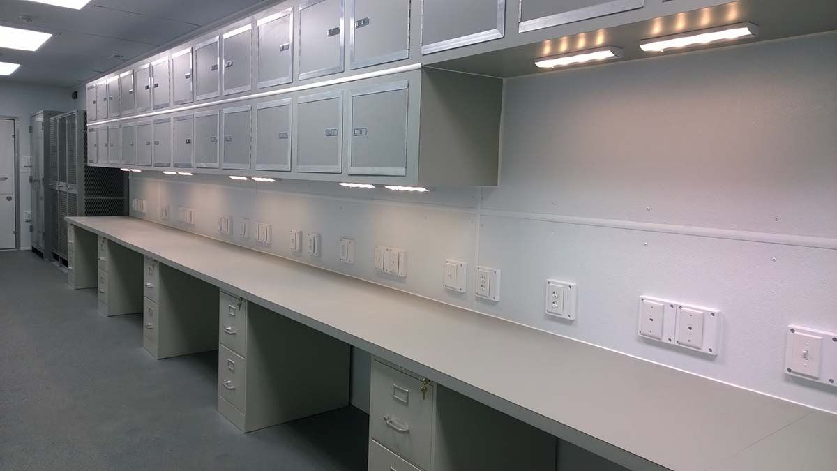 A long row of desks and cabinets in a room.