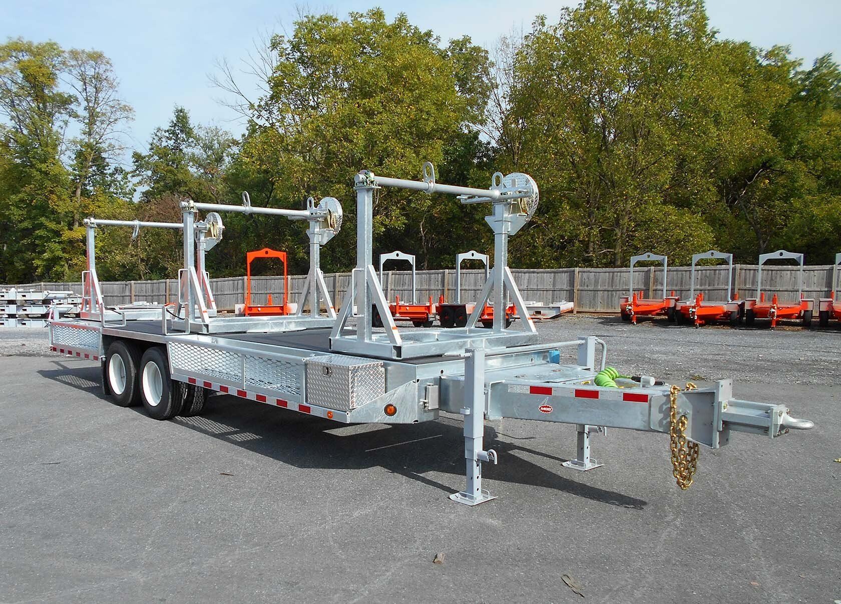 A trailer is parked in a parking lot with trees in the background