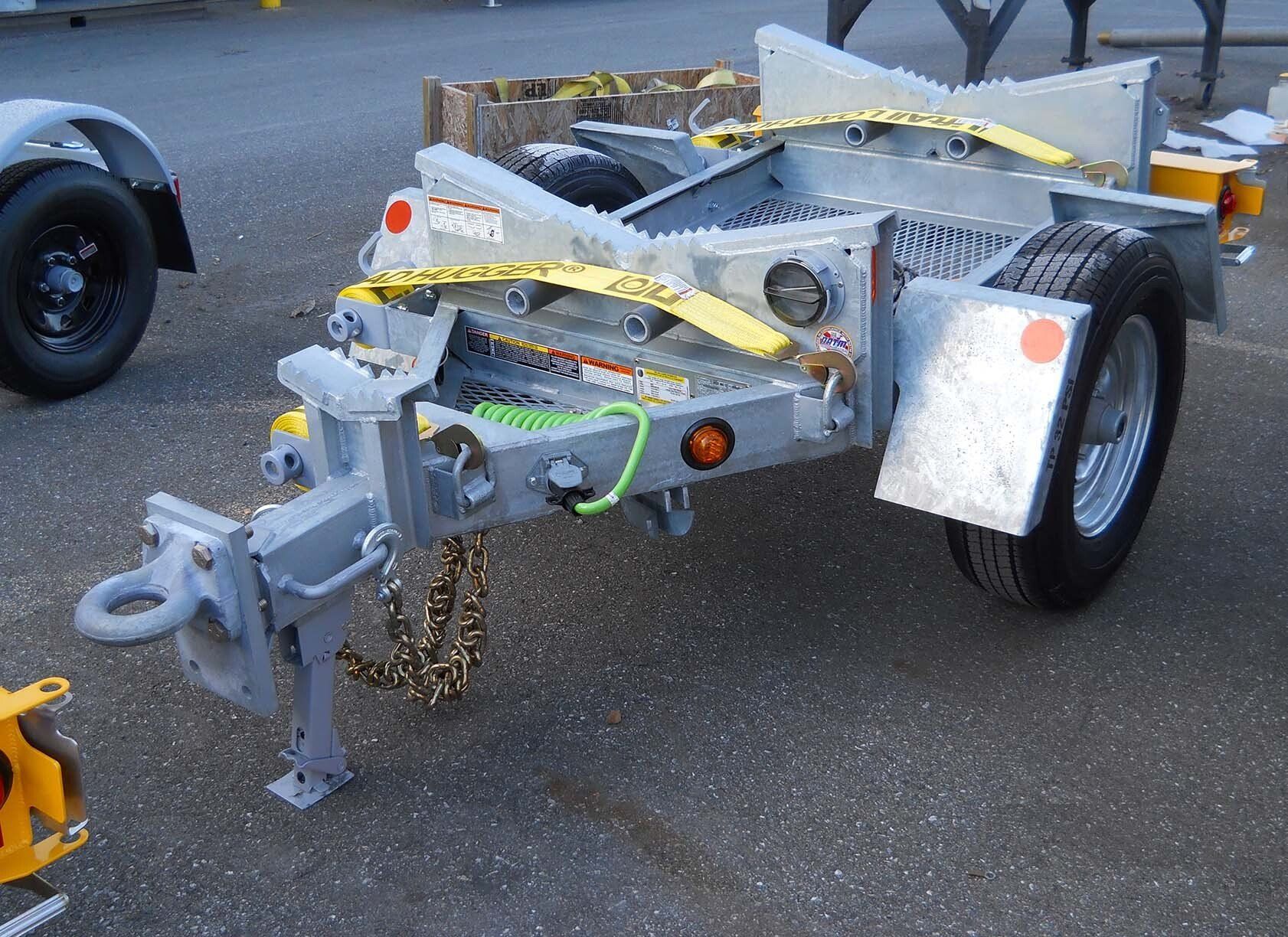 A gray trailer with a yellow strap that says ' cobra ' on it