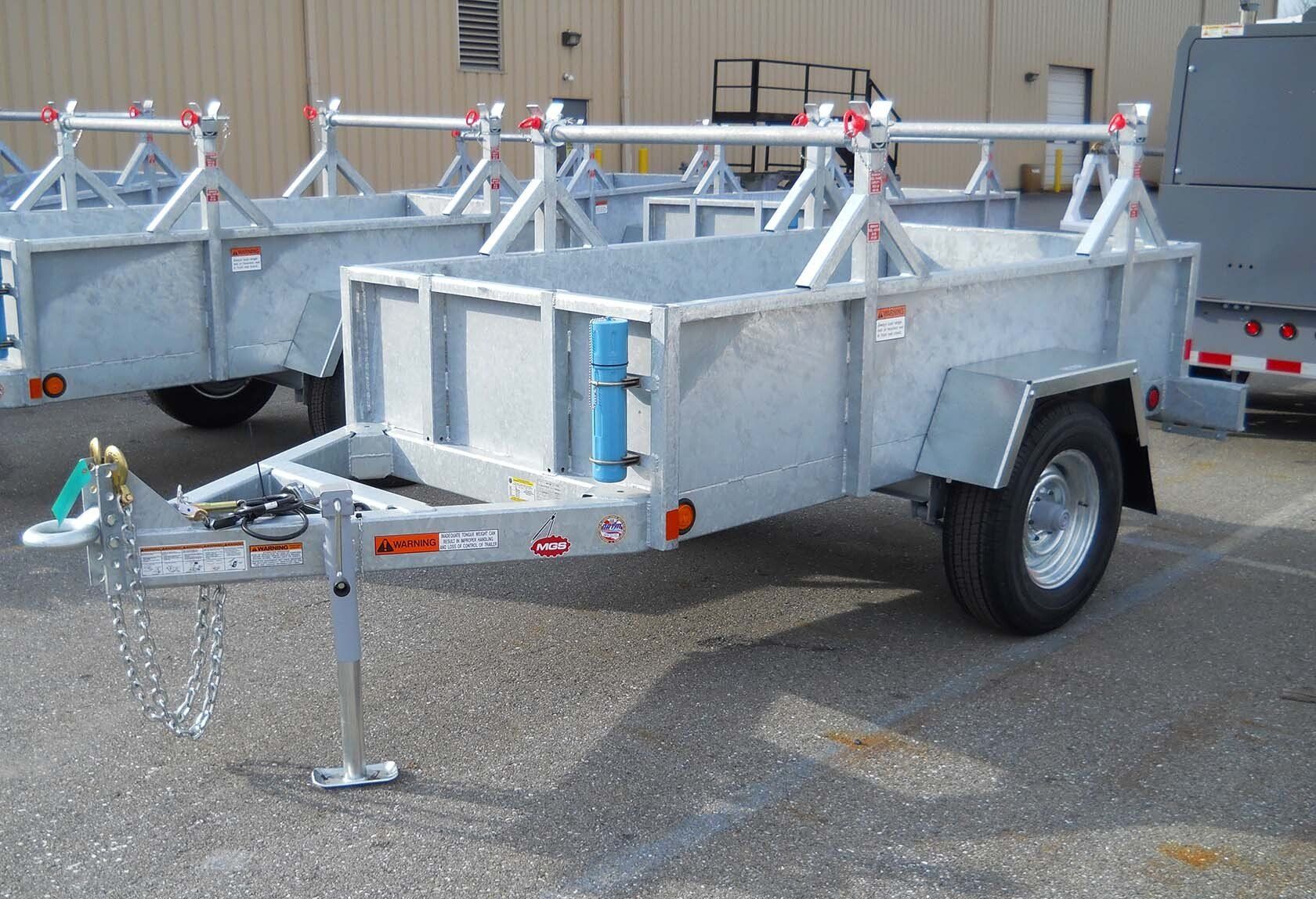 A row of trailers are parked in a parking lot