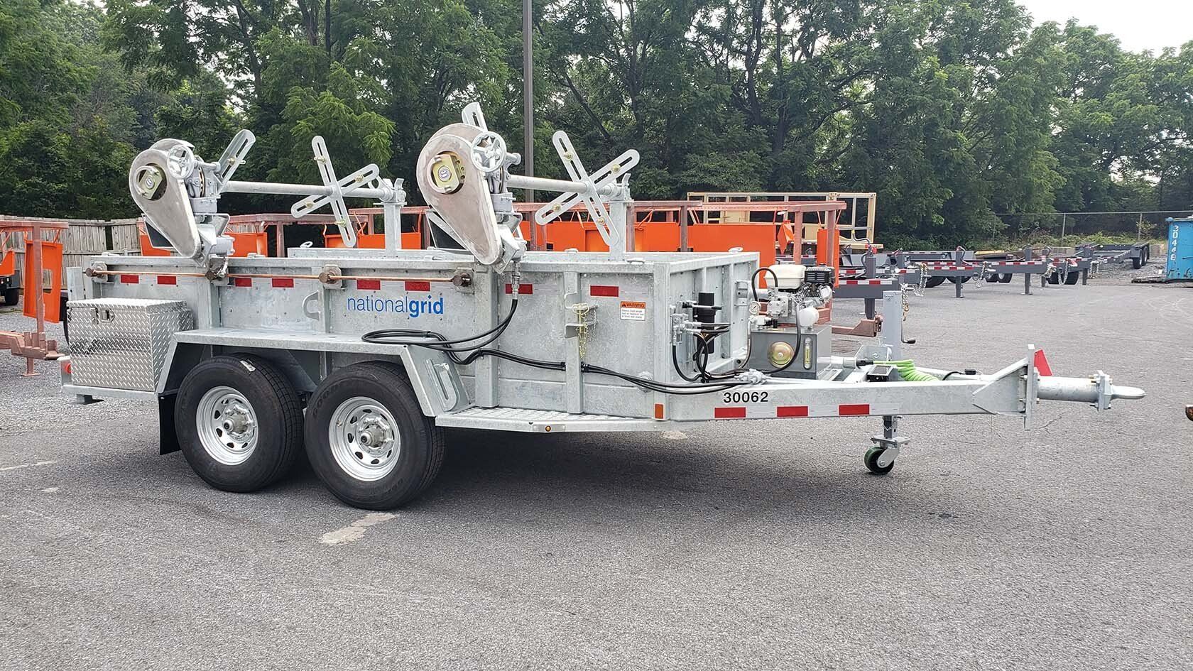 A dump trailer is parked in a gravel lot.