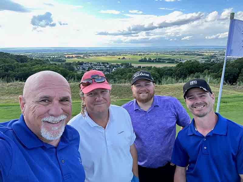 A group of men are posing for a picture on a golf course.