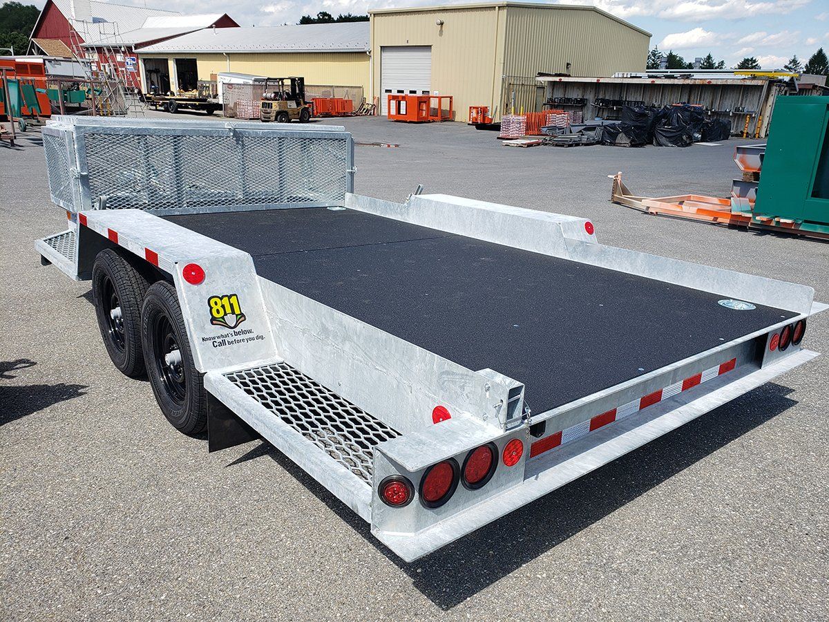 A white trailer is parked in a parking lot in front of a building