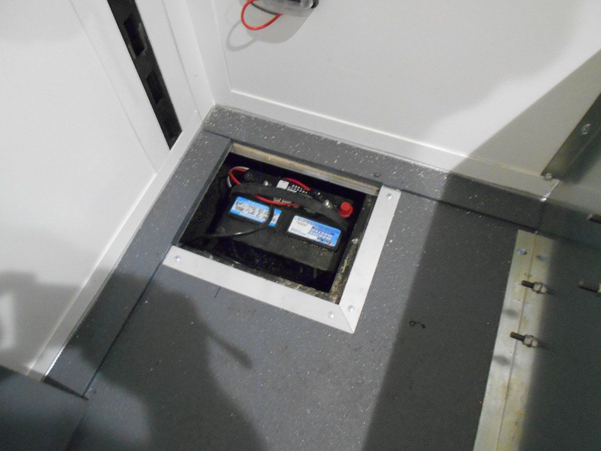 A battery is sitting in a hole in the floor