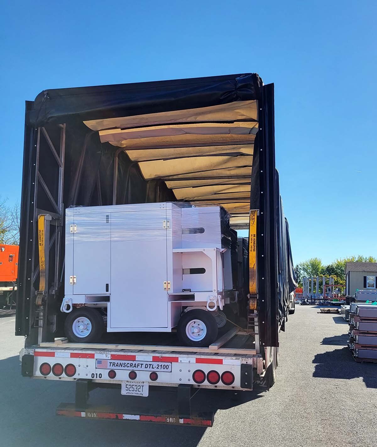 The back of a moving truck with a white box on the back