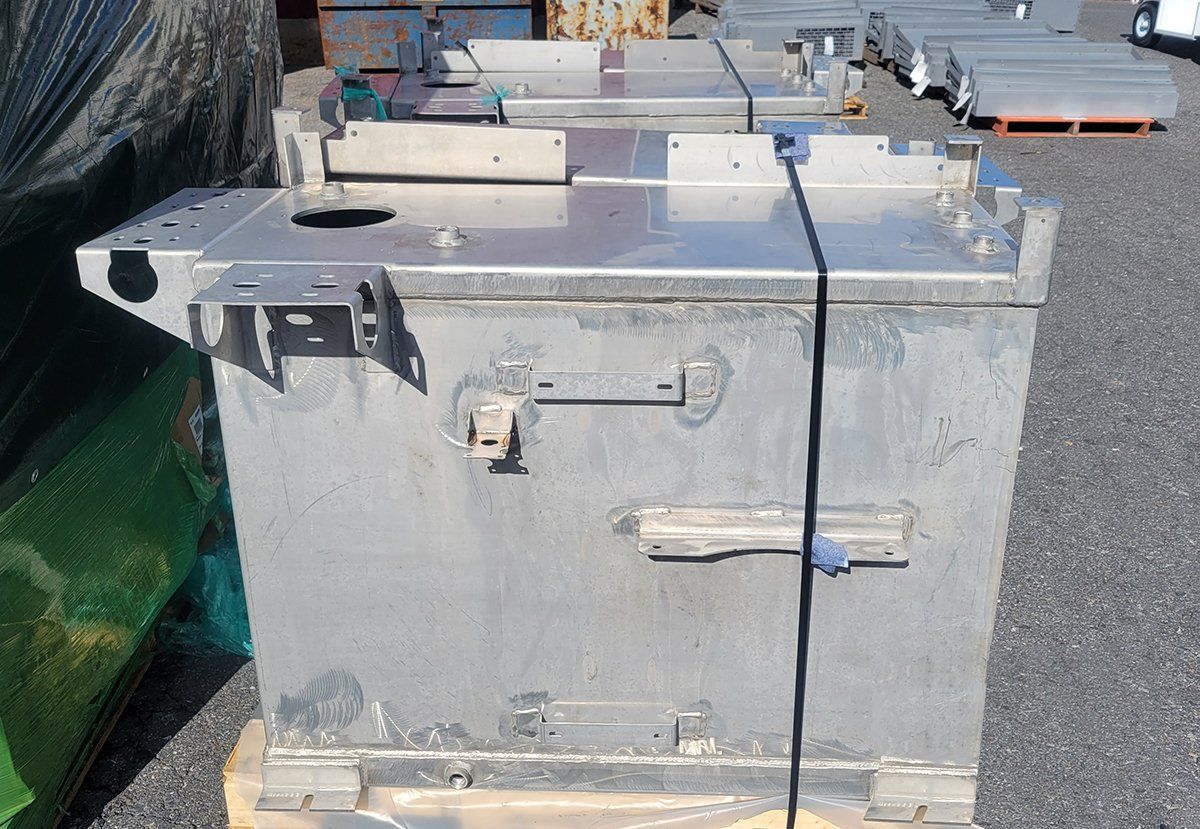 A stainless steel box is sitting on top of a wooden pallet.