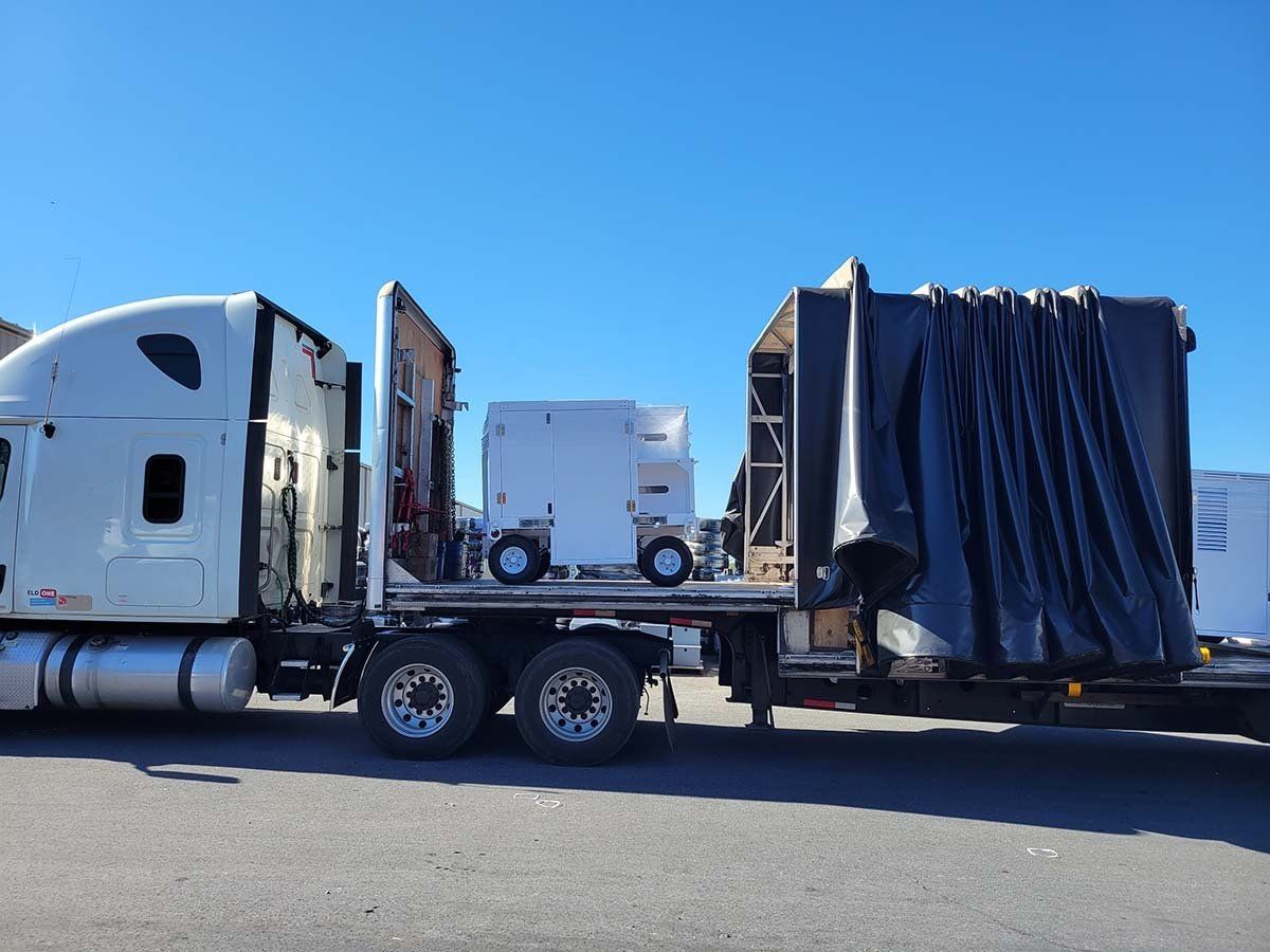 A semi truck with a trailer attached to it is parked in a parking lot.