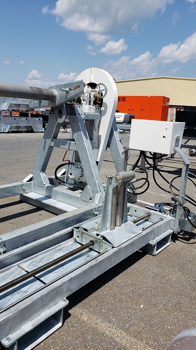 A large metal machine is sitting on the ground in front of a building.