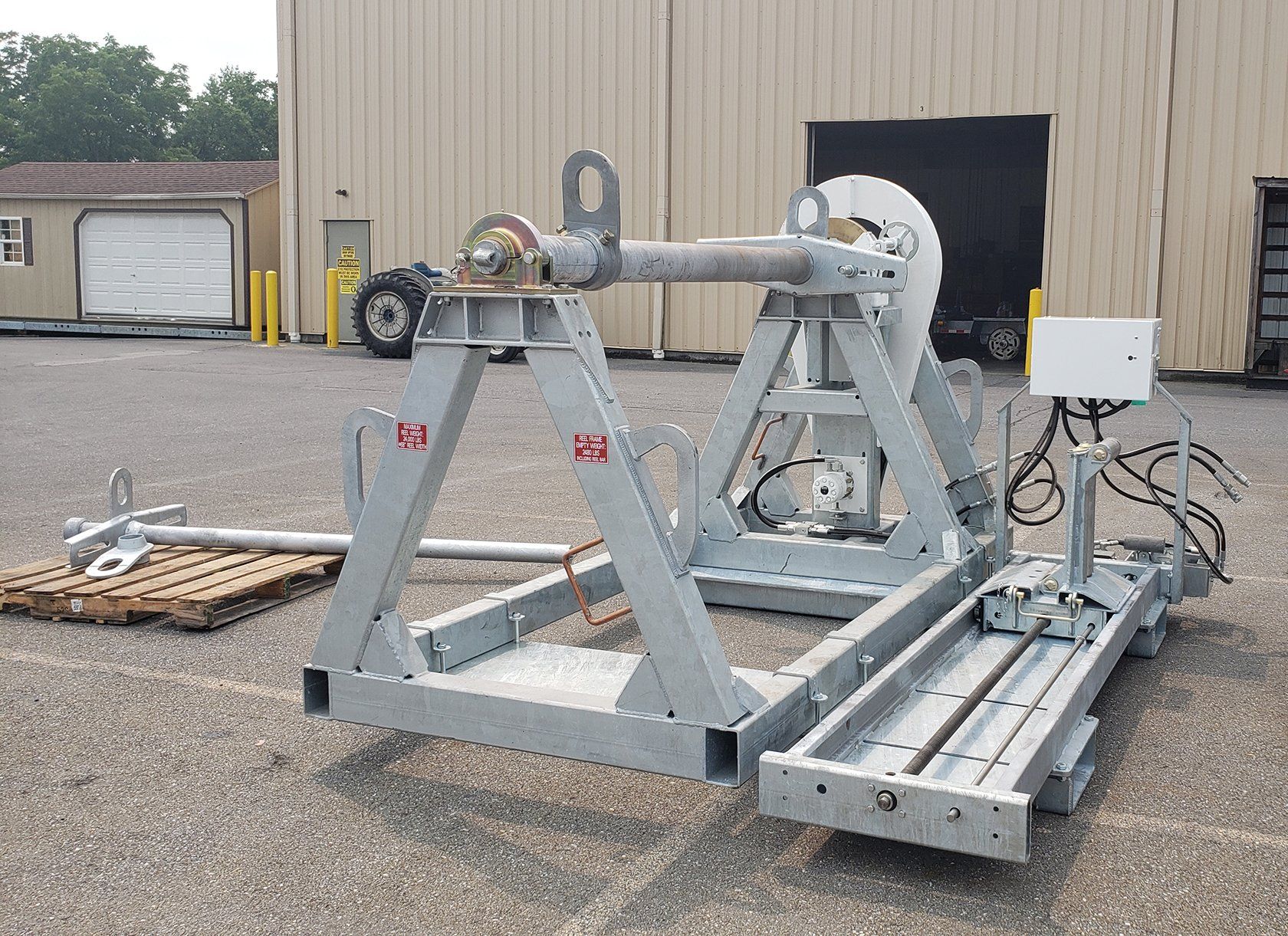 A large metal machine is sitting in a parking lot in front of a building.