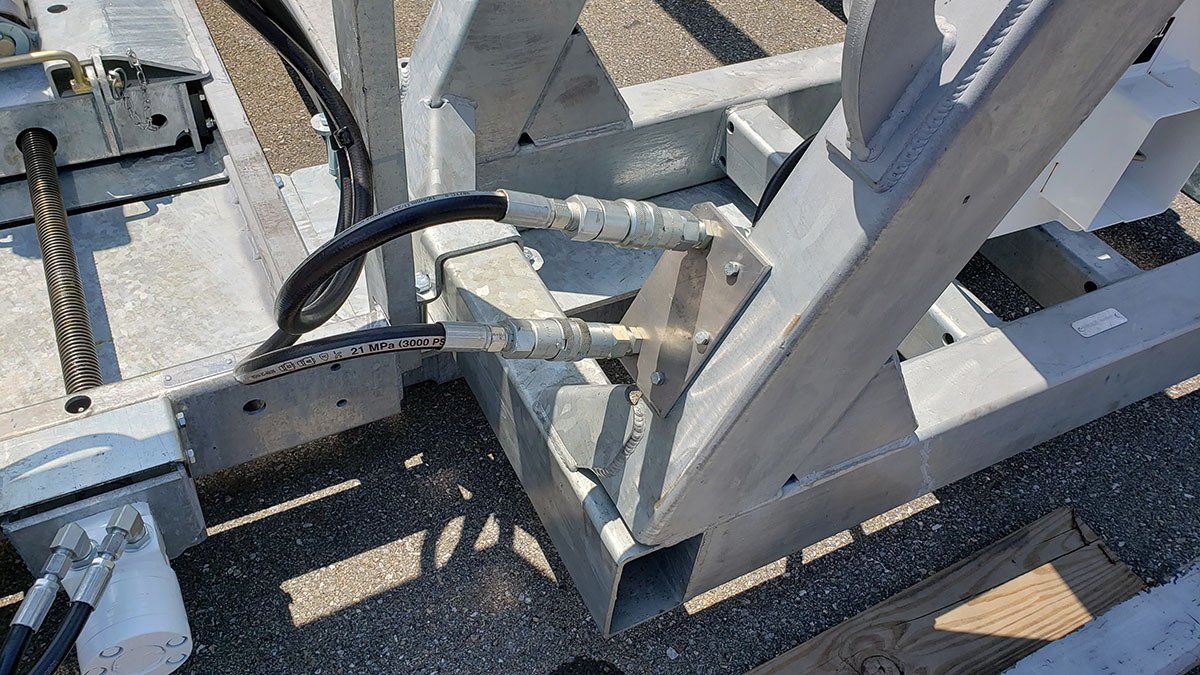 A close up of a metal structure with hydraulic hoses attached to it.