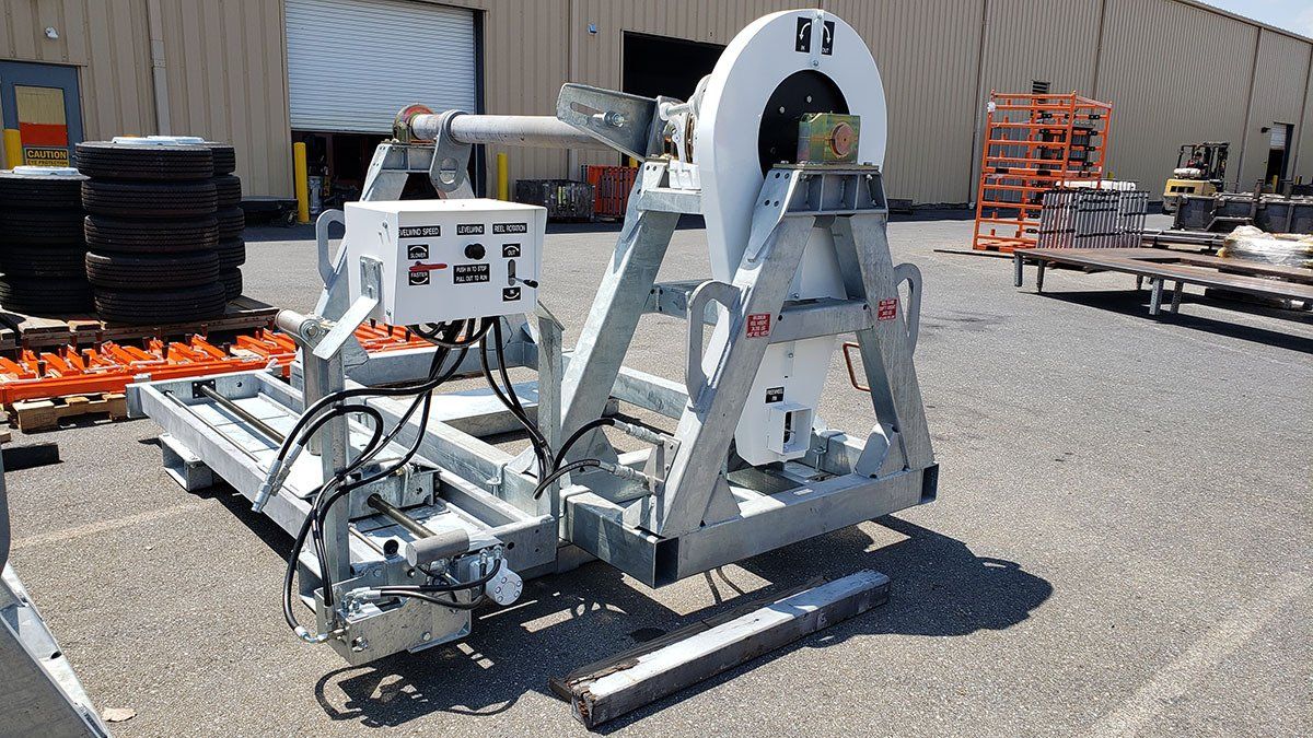 A large machine is sitting on the ground in front of a building.