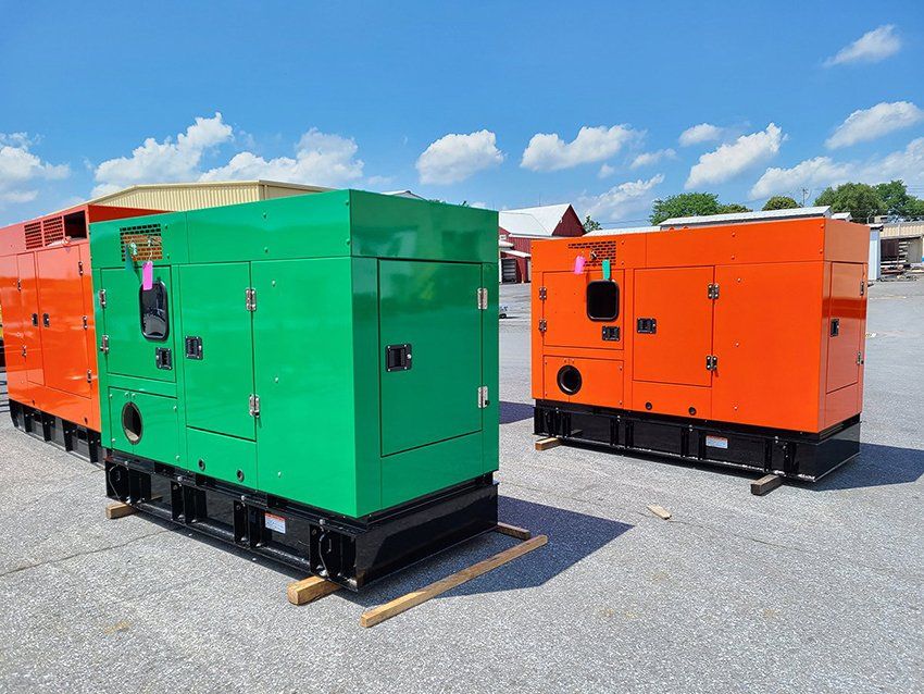 Three generators are parked next to each other in a parking lot.