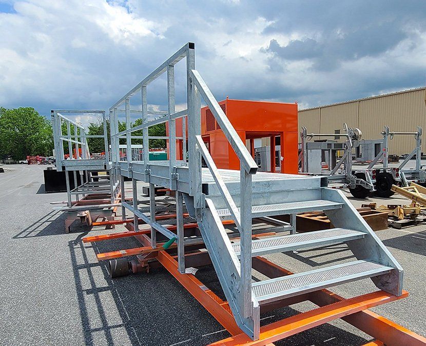 A set of stairs are sitting in a parking lot in front of a building.