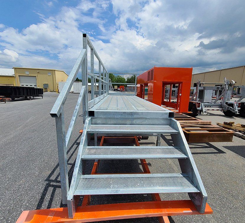 A metal platform with stairs and a railing in a parking lot