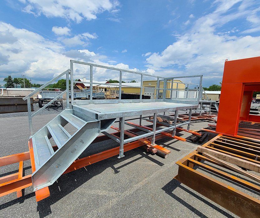 A metal platform with stairs and a railing in a parking lot