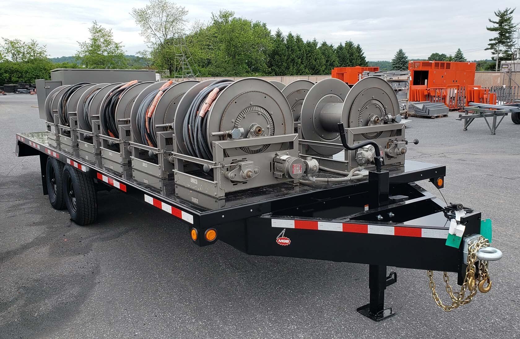 A trailer with a bunch of hose reels on it.