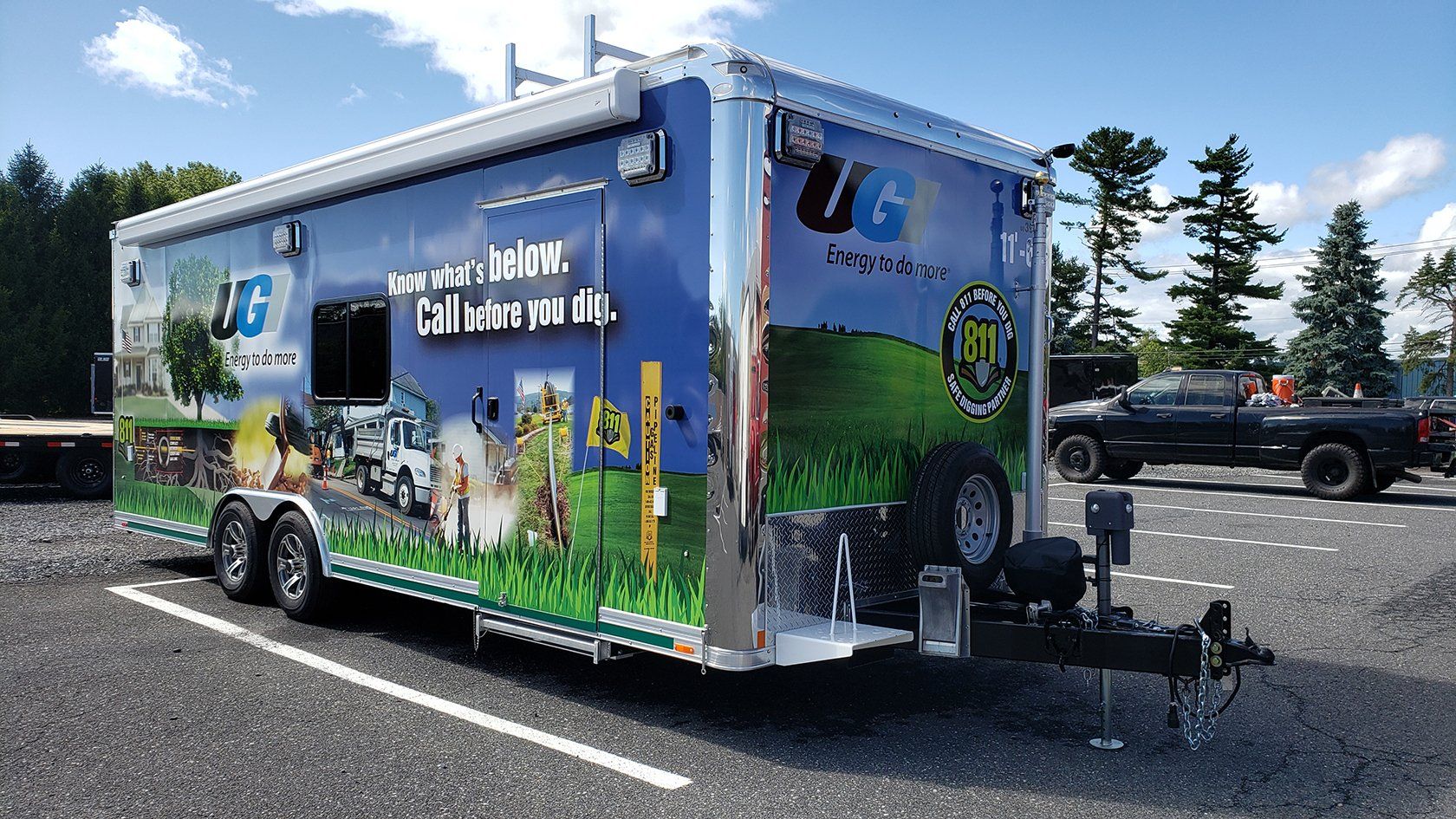 A trailer is parked in a parking lot next to a truck.