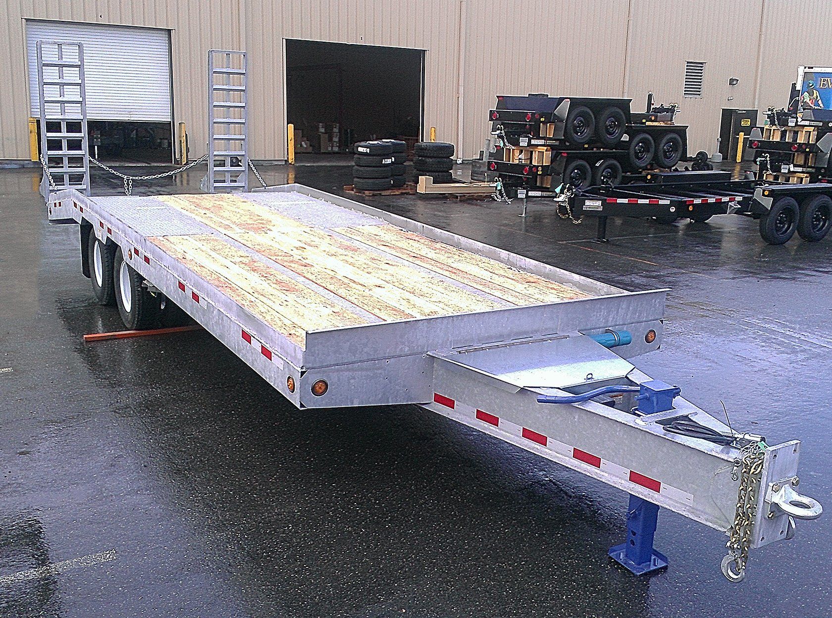 A flatbed trailer is parked in front of a building