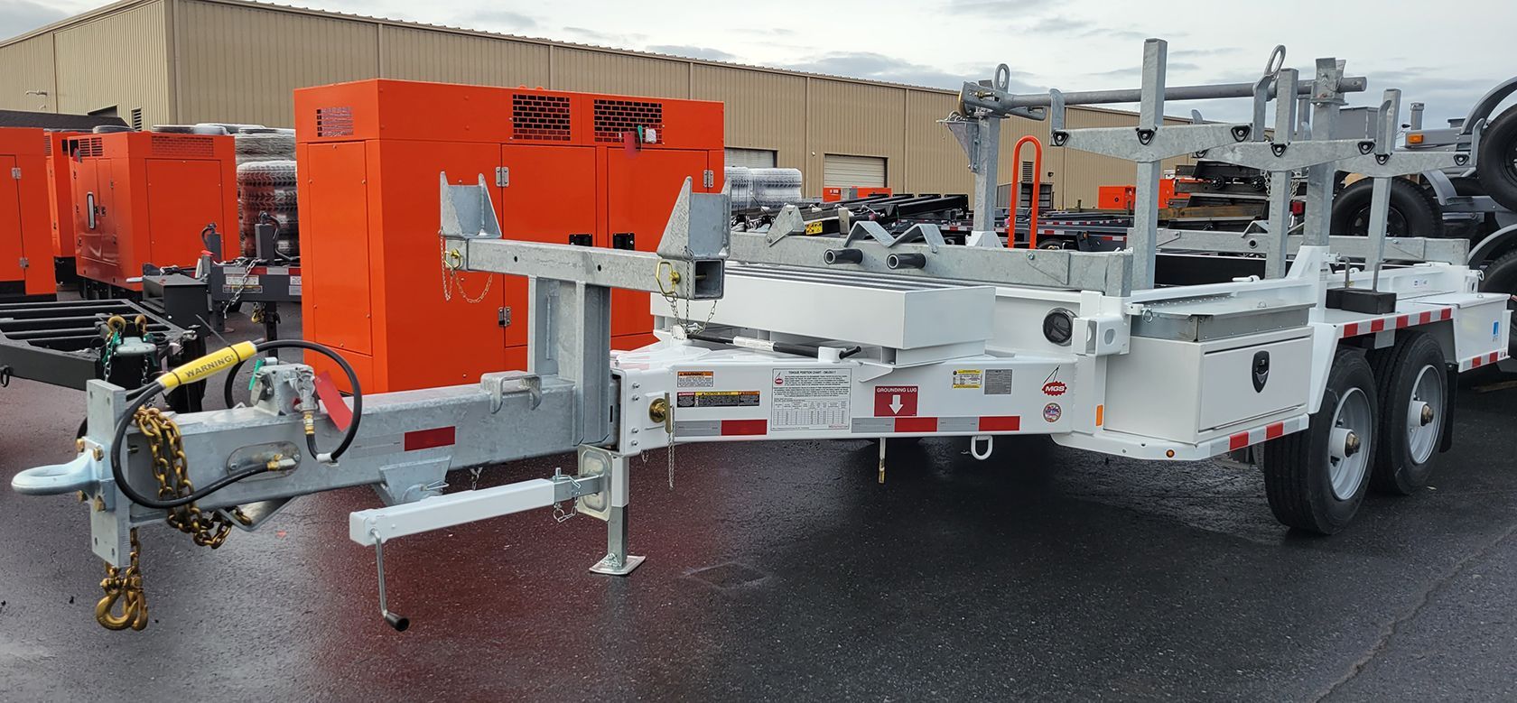 A trailer with a generator attached to it is parked in front of a building.