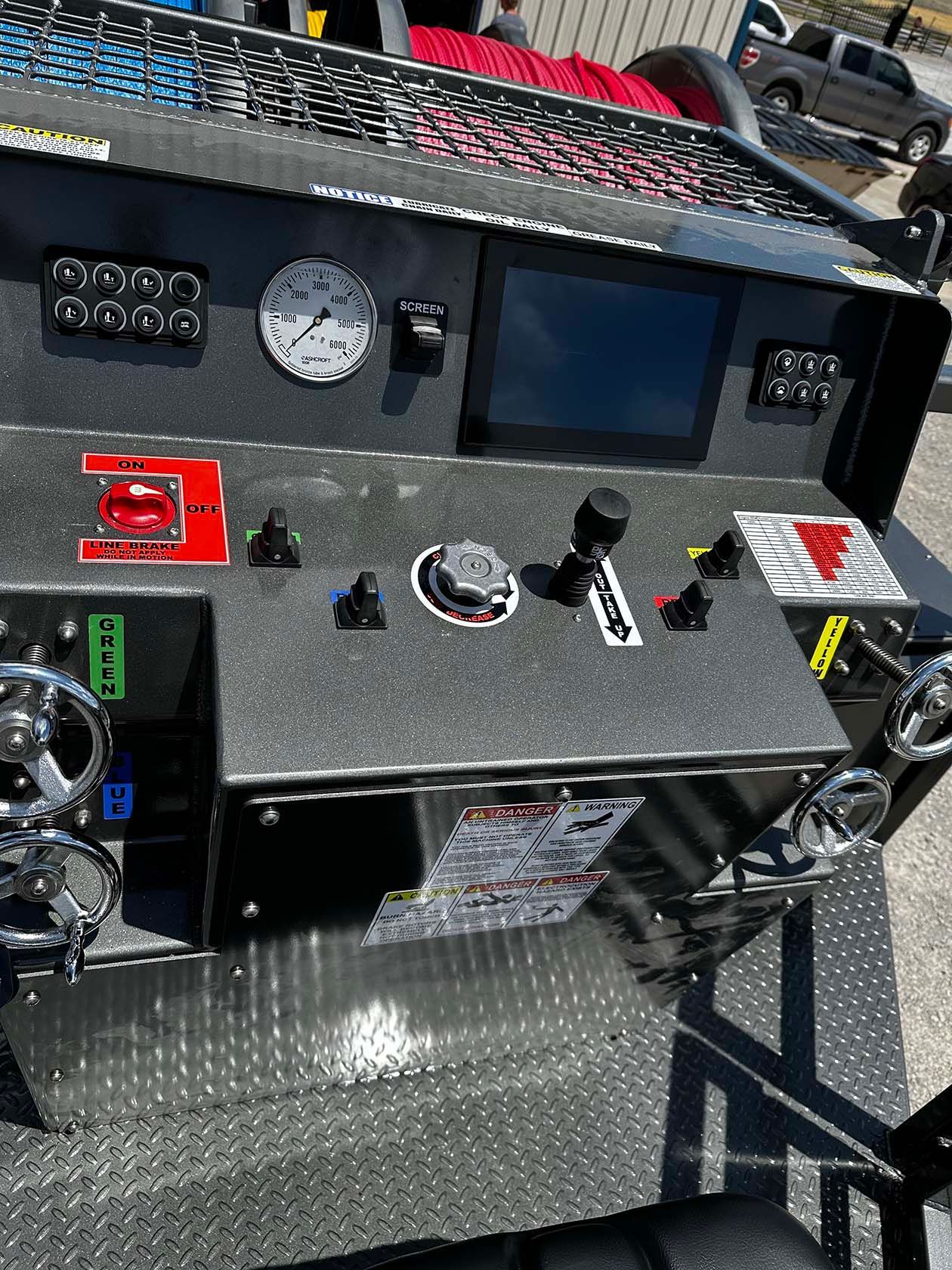 A dashboard of a truck with a clock and a monitor on it.