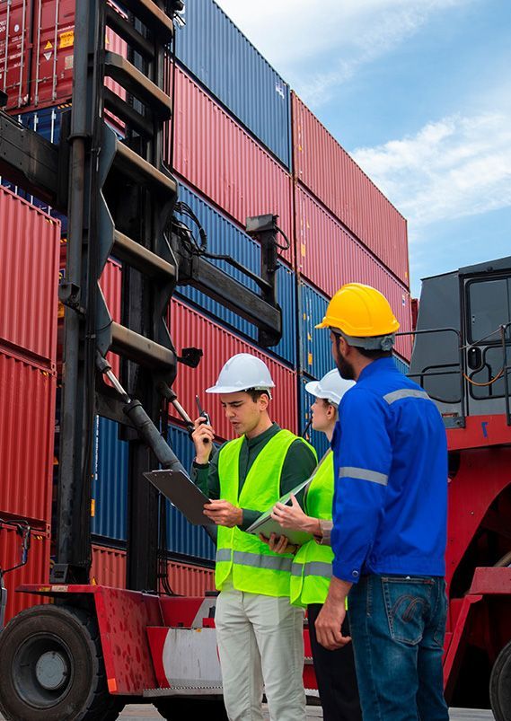 A group of construction workers are standing in front of a forklift and looking at a clipboard.
