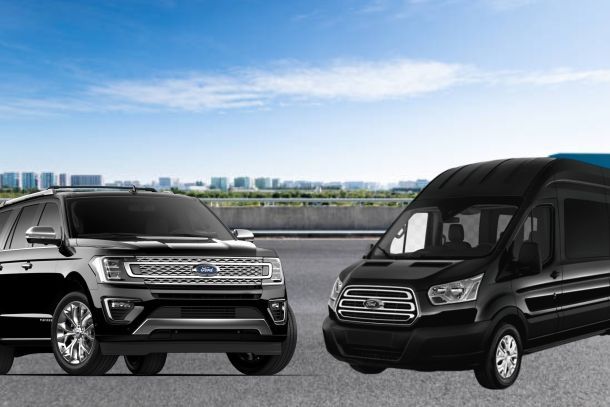 Black SUV and van parked outdoors on a sunny day.