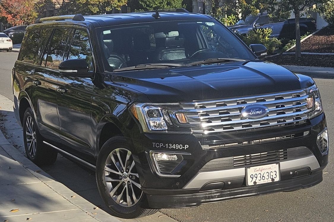 Black Ford Expedition SUV parked on a city street.