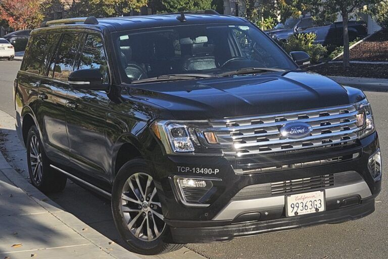 Black Ford Expedition parked on a sunny street, California license plate.