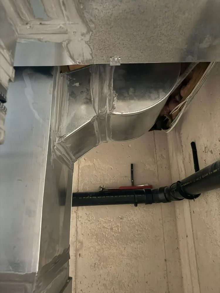 A metal pipe is hanging from the ceiling of a room.