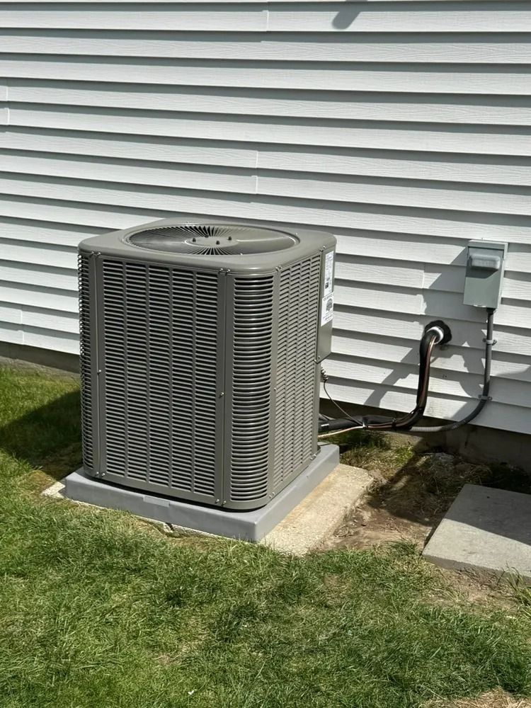 An air conditioner is sitting on the side of a house.