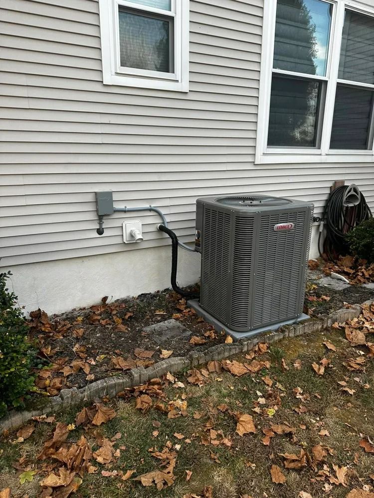 An air conditioner is sitting on the side of a house.