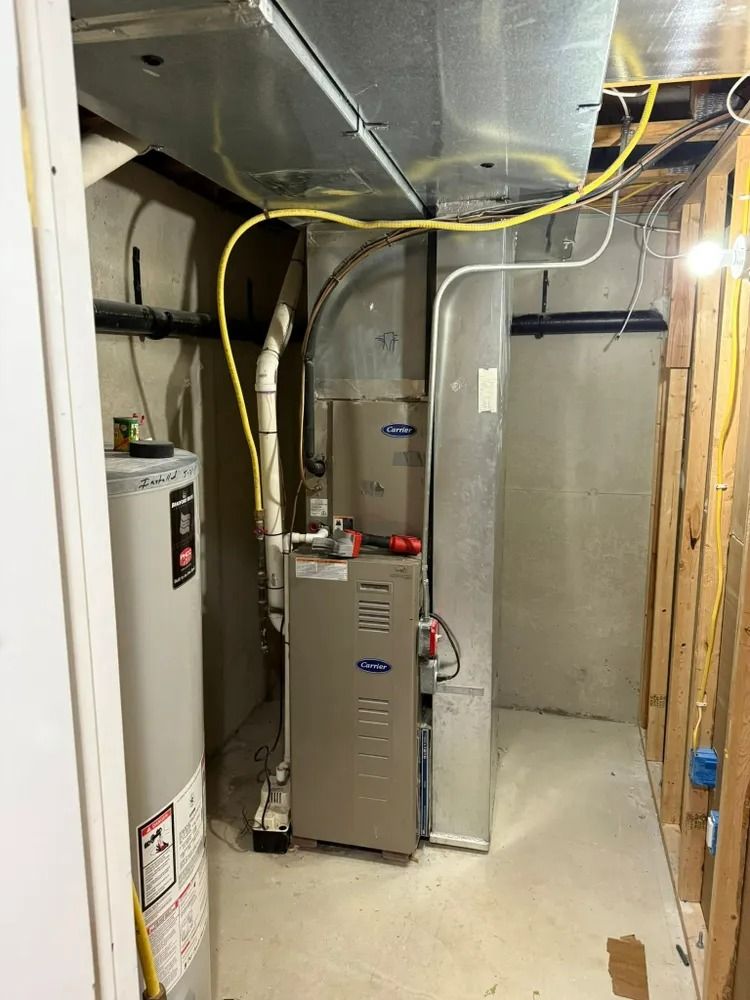 A room with a water heater and a furnace in it.