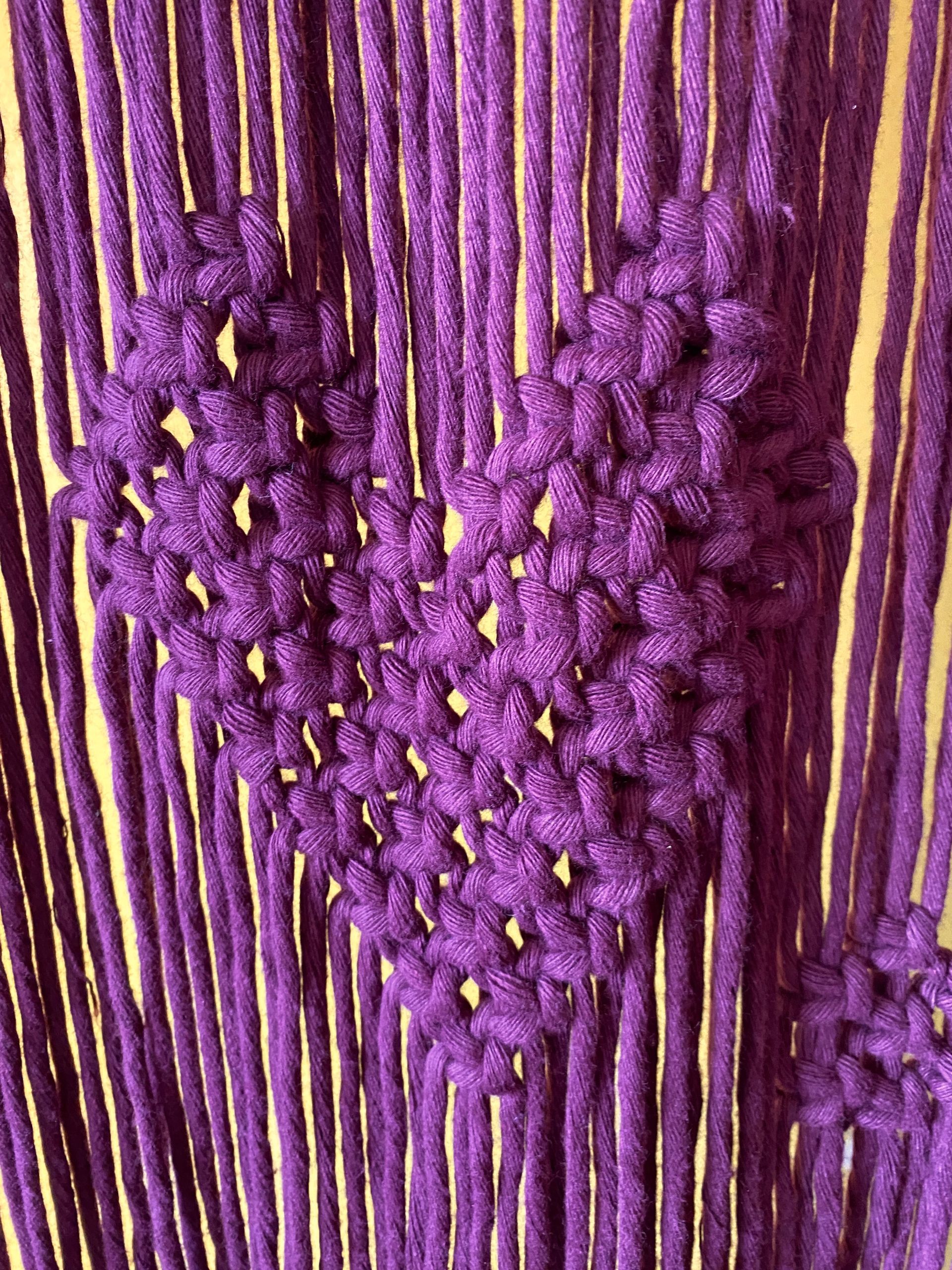 Close up of purple curtain detail; cotton cord knotted to form a heart motif.