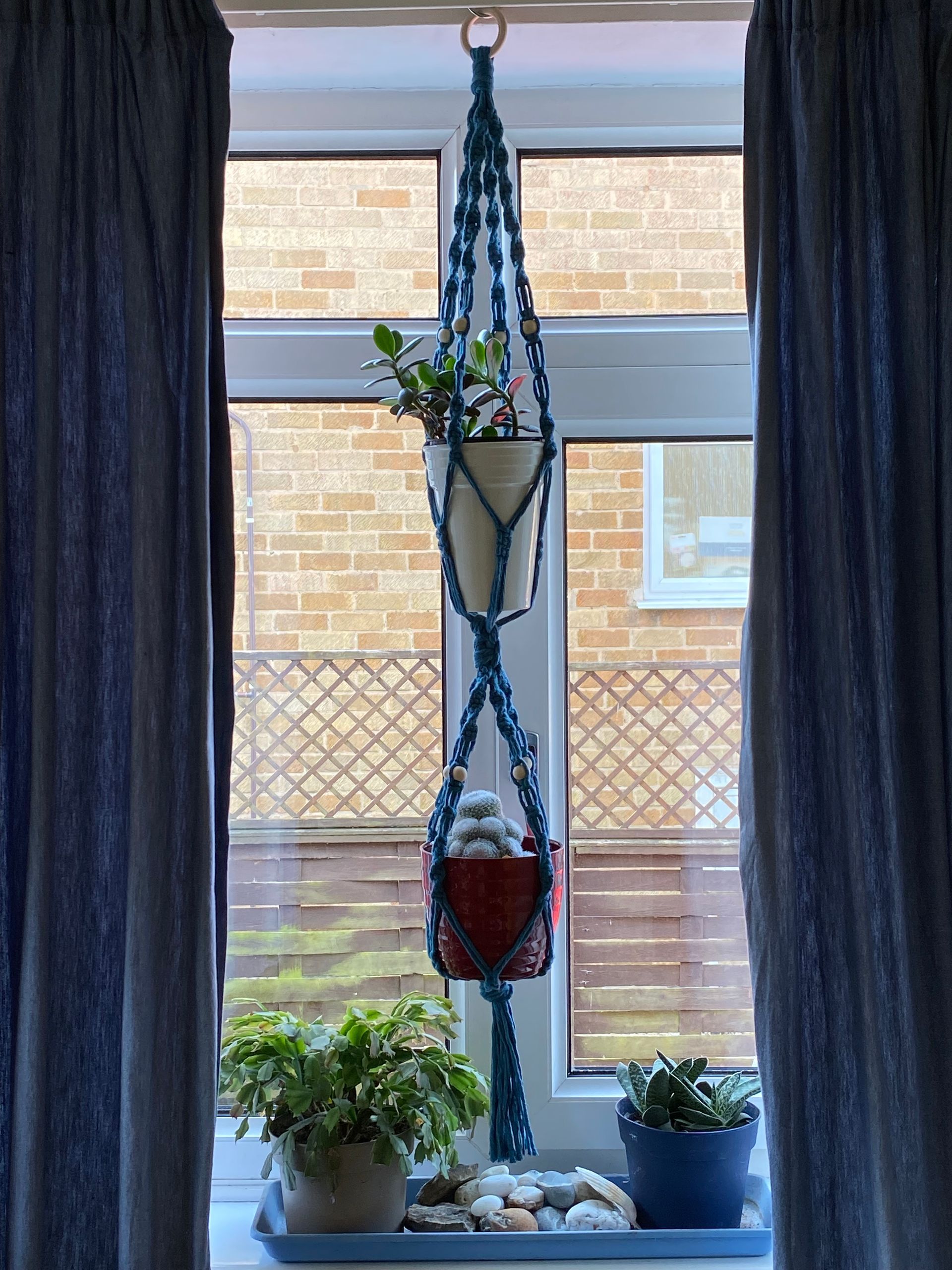 Double plant hanger made from 4mm teal cotton cord and light wooden beads.